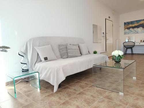 een woonkamer met een witte bank en 2 tafels bij Nafplio pleasure project in Nafplio