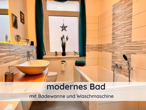 a bathroom with a tub and a sink and a toilet at Der Fuchsbau - Ferienwohnung "Auszeit Harz" - 3 Hunde willkommen - eingezäunter Garten in Bad Sachsa