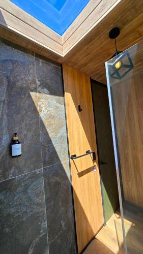 a wooden door in a room with a glass wall at Tiny house, comfort and peace facing Chimborazo in Riobamba