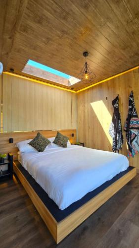 a bedroom with a large bed in a wooden wall at Tiny house, comfort and peace facing Chimborazo in Riobamba