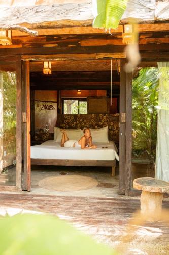 a woman laying on a bed in a bedroom at Mayan Monkey Isla Mujeres - Social Hotel in Isla Mujeres