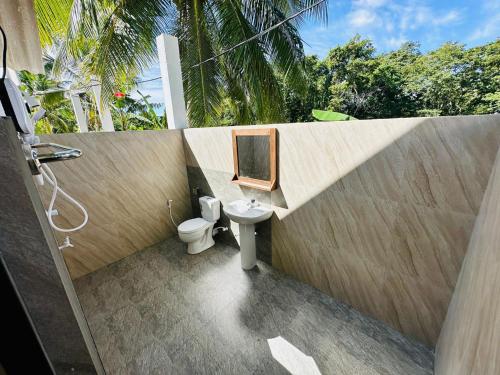 a bathroom with a sink and a toilet and a mirror at White House Safari Cottage in Udawalawe