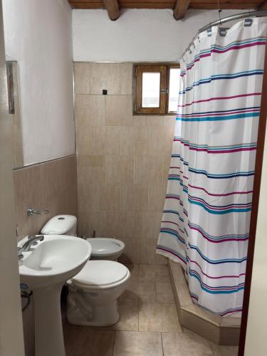 a bathroom with a sink and a toilet and a shower curtain at Cabañas Las Victorias in Colón