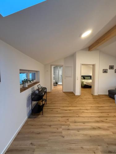 een woonkamer met een houten vloer en witte muren bij Leni Vacation Rental in Hattert