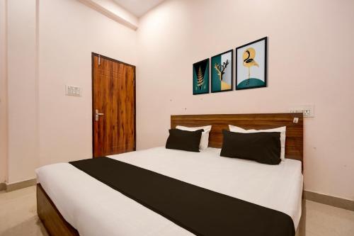 um quarto com uma grande cama branca com almofadas pretas em Hotel O Haven Palace em Alambagh