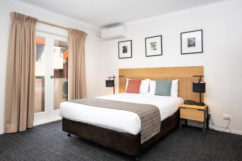 Una habitación de hotel con una cama y una ventana. en MainStay Suites Kew, en Melbourne
