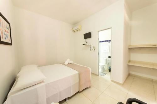 ein weißes Schlafzimmer mit einem Bett und einem Badezimmer in der Unterkunft Fonte dos Corais - Suíte Brisa da Tarde in Maragogi
