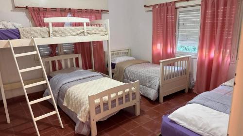 a bedroom with two bunk beds and twounks at cabaña EL CHALECITO DE ANA in Villa del Dique