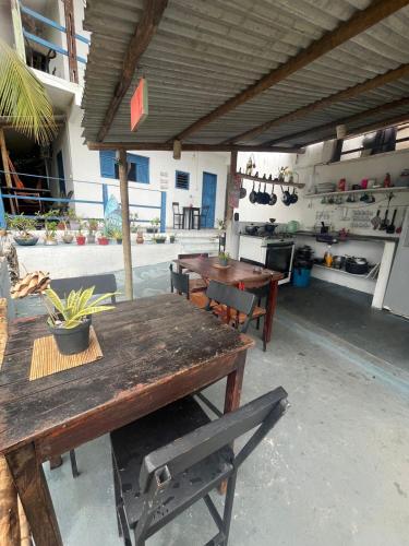 patio al aire libre con mesas de madera y cocina en VistaSurf Suites, en Pipa
