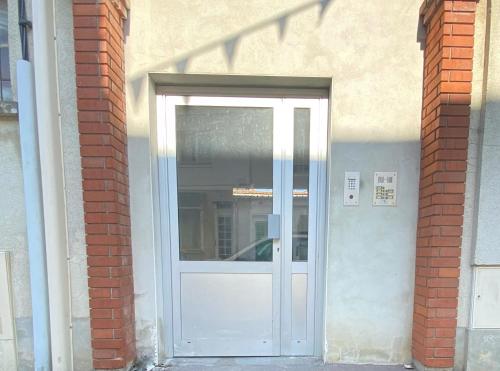 a white door in a brick building at La Suite Nocturne in Fère-en-Tardenois
