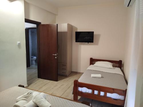 a small bedroom with a bed and a tv on the wall at Harmony Apartments in Larisa