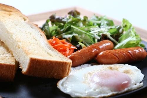 un piatto di cibo con un uovo e un'insalata di 旅館紀の国 