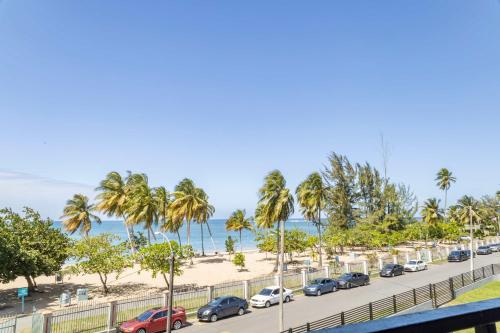 un aparcamiento con coches estacionados junto a la playa en Fully Renovated Beachfront Family Building 2 6 Beds 4 Baths Ocean Views & Terrace, en Dorado