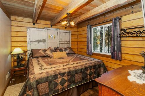 a bedroom with a bed in a log cabin at Riverfront, Authentic, Luxury Log Cabin-Bull Moose in Wasilla