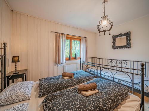 a bedroom with two beds and a chandelier at Tauernhaus Madelief in Piesendorf