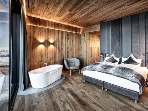 a bedroom with a bed and a bath tub at Mountain View Loft Bergkristall in Kaltenbach