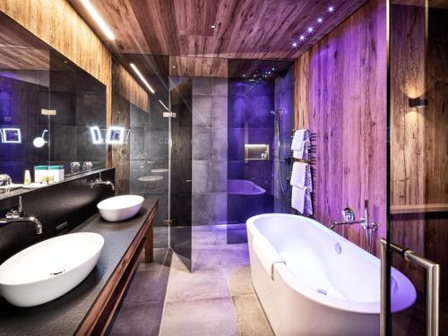 a bathroom with two sinks and a tub at Mountain View Loft Bergkristall in Kaltenbach