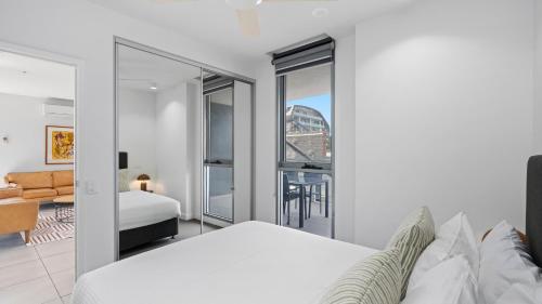 a bedroom with a bed and a view of a city at District Apartments Fitzroy in Melbourne