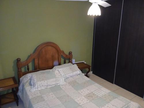 a bedroom with a bed with a wooden head board at Abuela Chela in Villa Carlos Paz