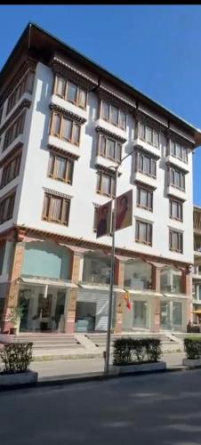 a large white building on the side of a street at Hotel pema raga in Thimphu