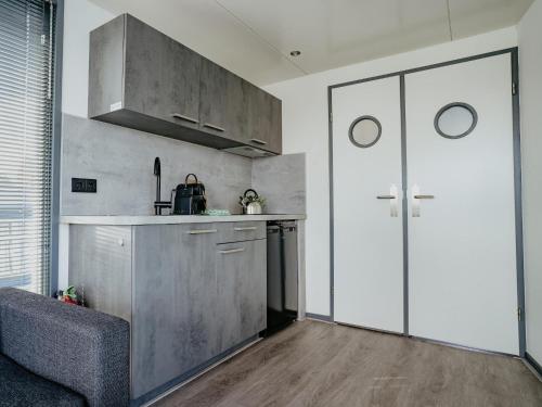 a kitchen with a large pivot door in a room at Harbour Lodge at Uitgeestermeer View in Uitgeest