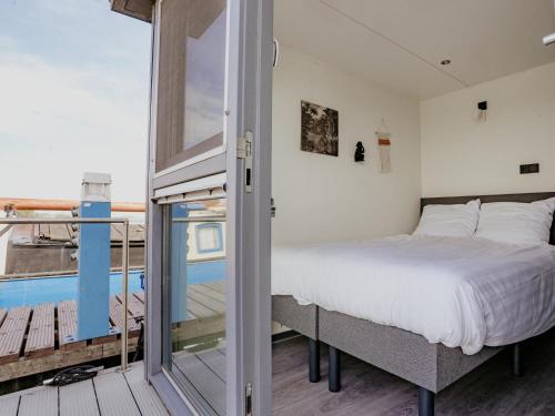 a bedroom with a bed and a balcony at Harbour Lodge at Uitgeestermeer View in Uitgeest