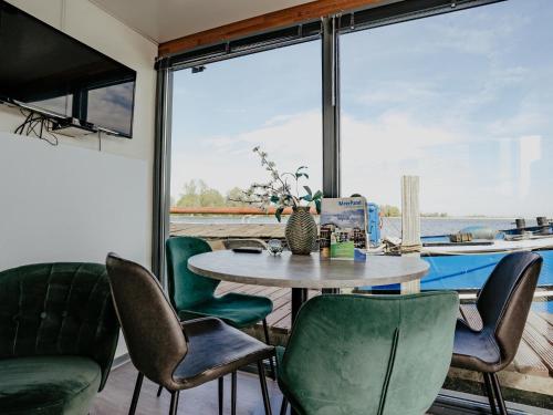a dining room with a table and green chairs at Harbour Lodge at Uitgeestermeer View in Uitgeest