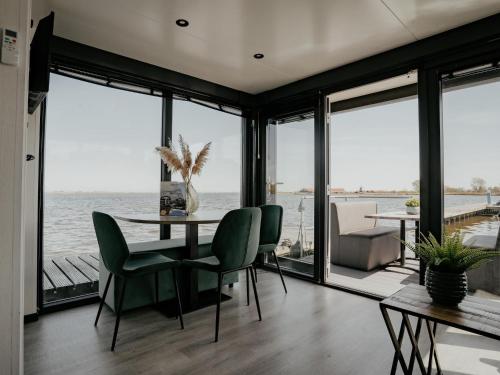 a dining room with a view of the water at Luxury Houseboat Getaway in Uitgeest