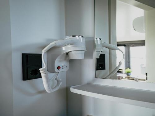 a white hair dryer on a wall next to a mirror at Luxury Houseboat Getaway in Uitgeest