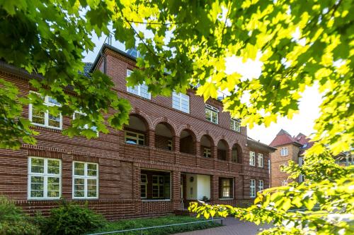 a large brick building with trees in the foreground at Villa Höger in Boltenhagen