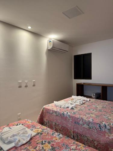 a hotel room with two beds and a tv at Flat Garden Frances in Marechal Deodoro