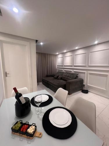 una sala de estar con una mesa y un sofá en Apartamento Luxo à 20 minutos do Cumbuco, en Caucaia