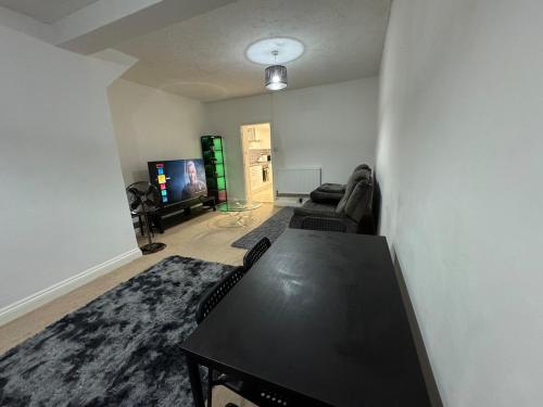 ein Wohnzimmer mit Tisch und Fernseher in der Unterkunft The fulfilling dover retreat in Dover