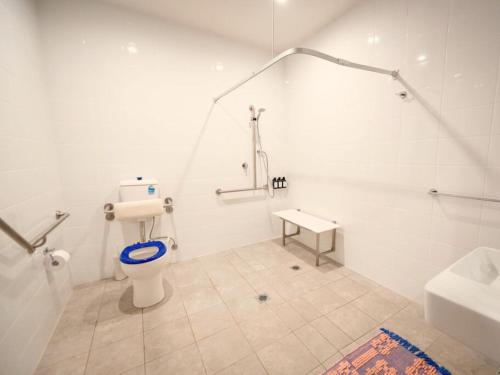 a white bathroom with a toilet and a sink at The Sienna Hunter Valley in Luskintyre