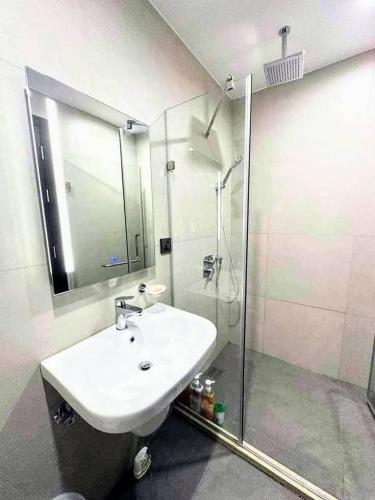 a bathroom with a white sink and a shower at aeon condon studio unit in Davao City