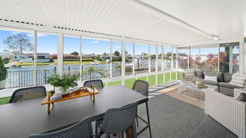 a porch with a table and chairs and a view of the water at Hibbard Waterfront Escape in Port Macquarie