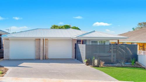 a house with two garage doors in a driveway at 52A Chalmers Street Flynns Beach in Port Macquarie