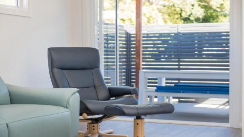two chairs and a chair in a room with a window at 52A Chalmers Street Flynns Beach in Port Macquarie