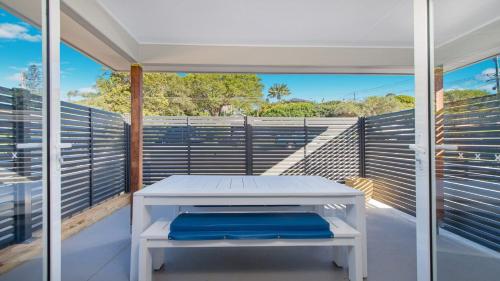 a white bench on the balcony of a house at 52A Chalmers Street Flynns Beach in Port Macquarie