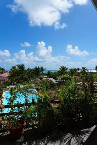 een balkon met uitzicht op het zwembad van een resort bij Cosy place with sea view in Oyster Pond