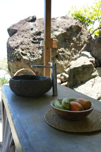 een fruitschaal op een tafel met een gootsteen bij Cosy place with sea view in Oyster Pond