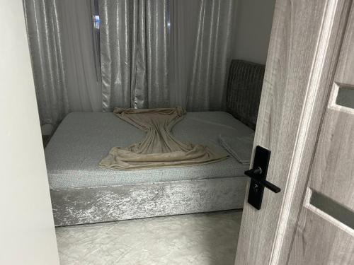 un petit lit dans une chambre avec une fenêtre dans l'établissement Apartament Târg Craciun, à Craiova
