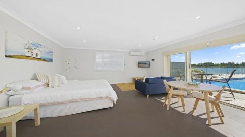 a bedroom with a bed and a table and a view at Studio Living in Port Macquarie