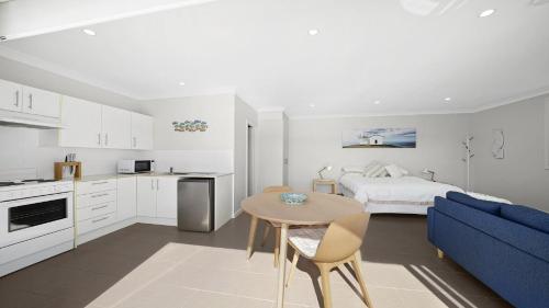 a kitchen and living room with a bed and a table at Studio Living in Port Macquarie