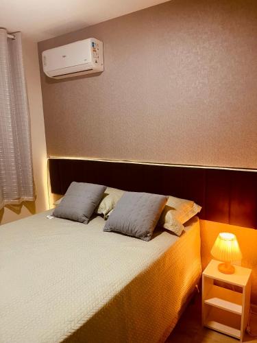 a bedroom with a bed with two pillows on it at Belize flat praia de Intermares in Cabedelo
