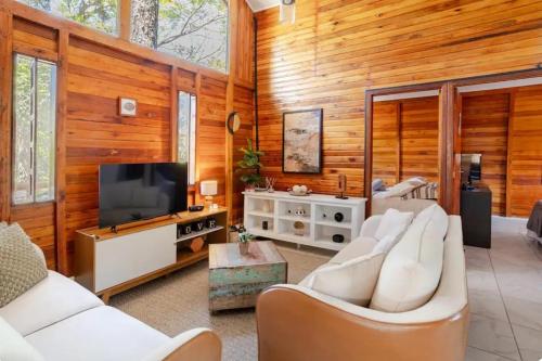 a living room with white furniture and a flat screen tv at Cabana em Itu-SP Chalé Veraneio Camping Carrion in Itu
