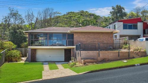 a brick house with a garage in a yard at 9 Matthew Flinders Drive in Port Macquarie