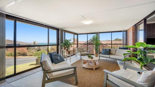 a living room with large windows and a view of the ocean at 9 Matthew Flinders Drive in Port Macquarie