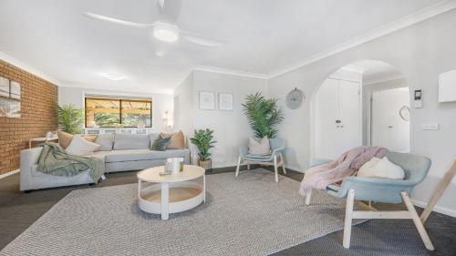 a living room with a couch and two chairs at 9 Matthew Flinders Drive in Port Macquarie