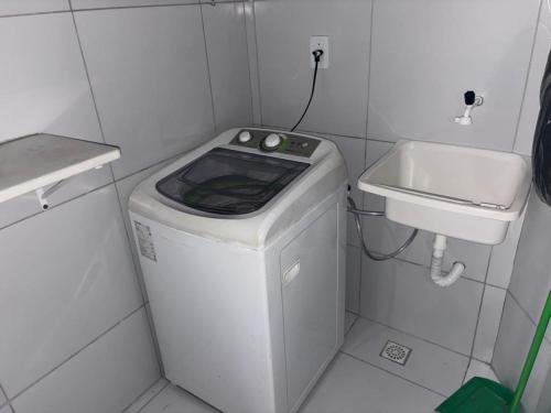 ein kleines Badezimmer mit Waschmaschine und Waschbecken in der Unterkunft Apartamento Mobiliado! in João Pessoa